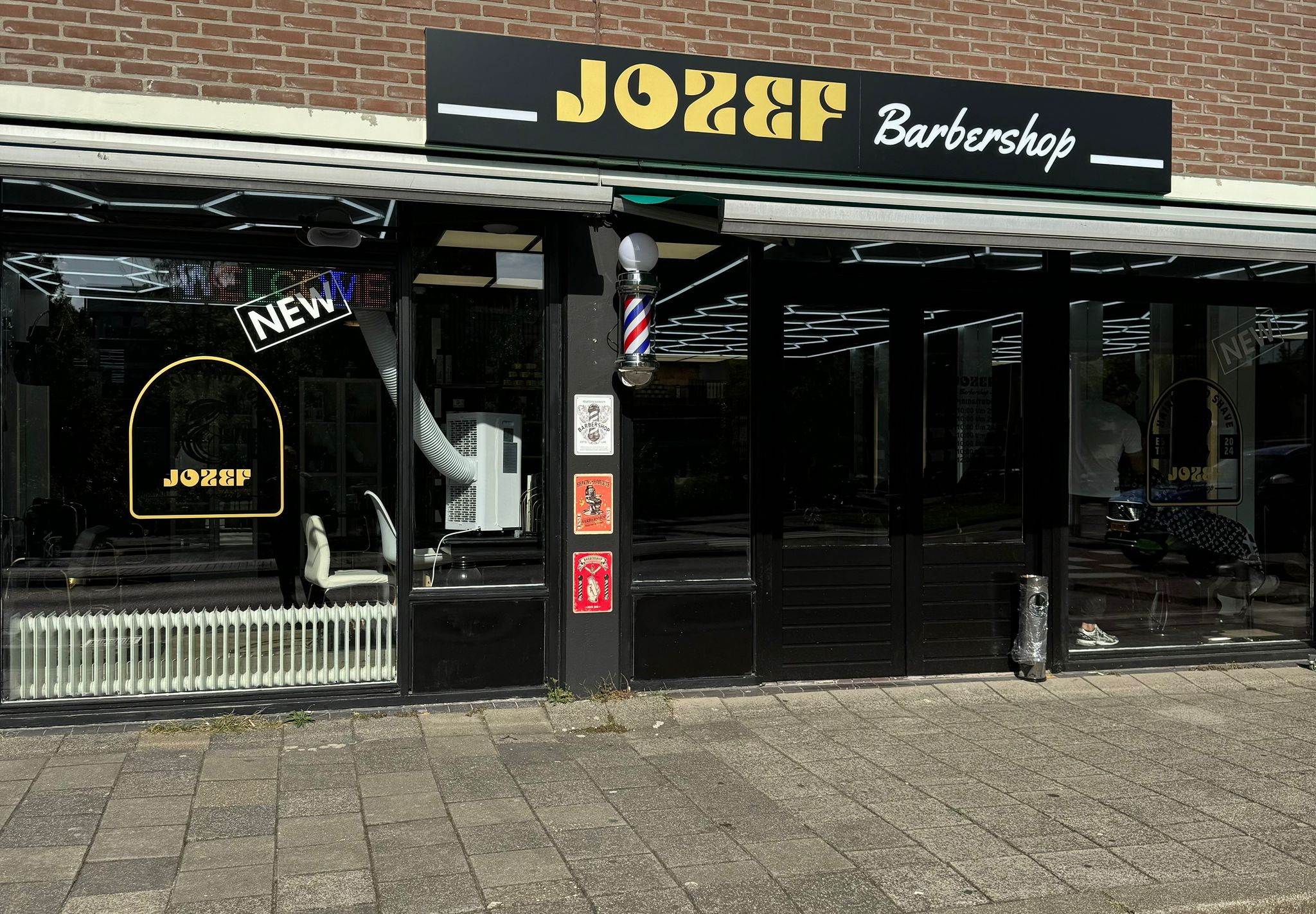 De winkelpui van Jozef barbershop aan het Hollandsch Diep, met het zwarte bord en de gouden letters JOZEF Barbershop