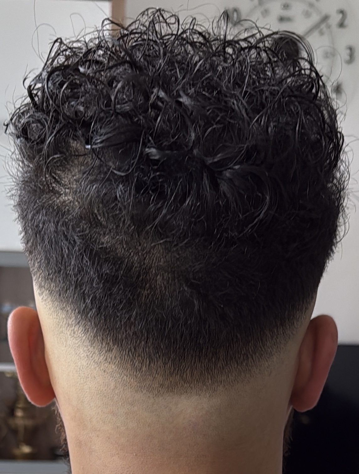 Achteraanzicht van krullen bovenop met een fade in de nek
